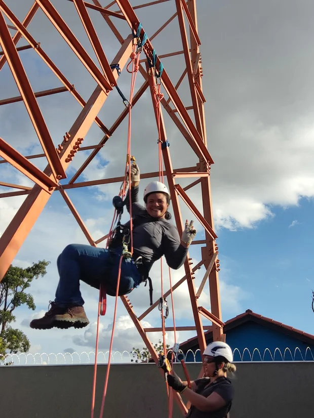 Aluna em descensão por corda na torre de treinamento