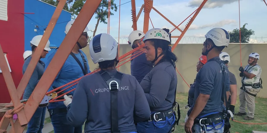 Equipe manuseando cordas e equipamento na base da torre